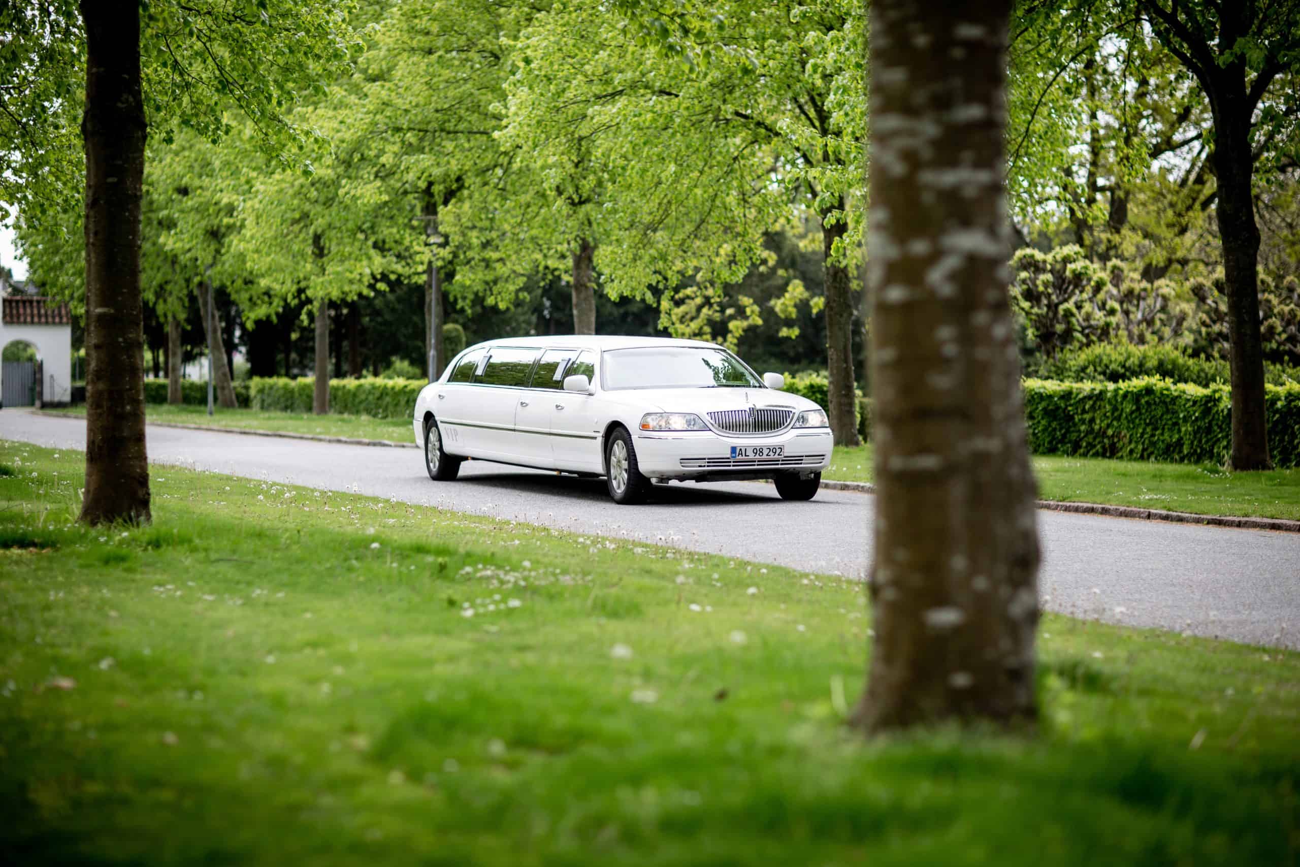 White Limousine Driving On Road 2504936 Scaled.jpg